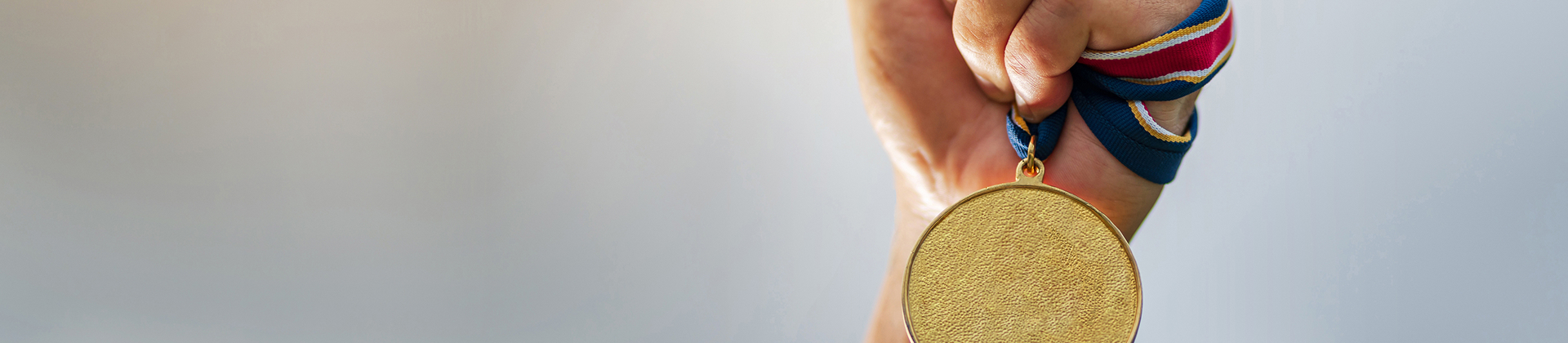 메달을 쥐고 하늘 높이 들고있는 손 사진